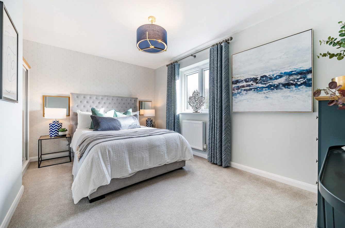 A bedroom with a centrally placed bed, flanked by dressed bedside tables.