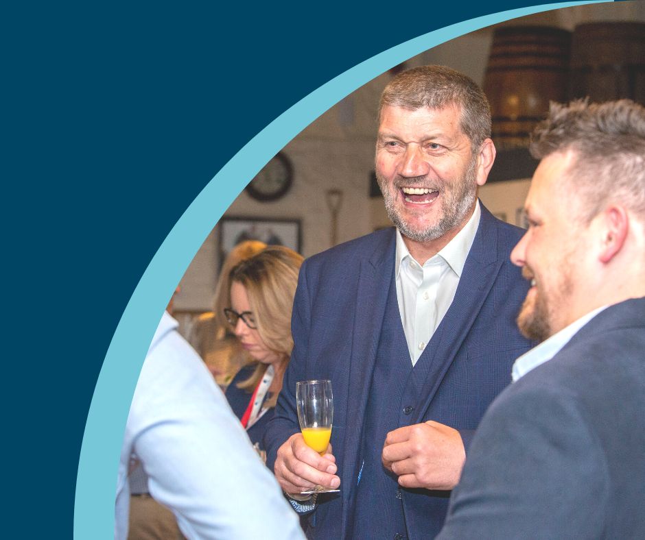 Staff members smiling as they raise a glass of fizz to toast the company’s 50th anniversary.